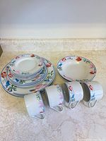 Stacked plates, bowls and mugs showing pattern and quantity