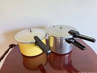 two Presto pressure cooker pots with lids on tabletop