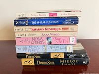 Stack of eight paperback romance novels showing spines and authors