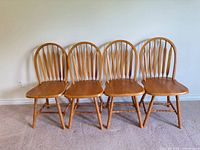 Four matching oak Windsor spindle-back dining chairs front view