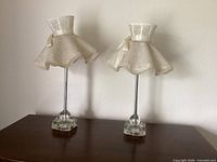 Both ivory glass table lamps with fabric shades shown on tabletop