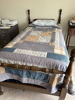 Full view of assembled twin wood bed frame with bedding removed from sale