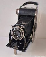 Front three-quarter view of folding camera with bellows extended