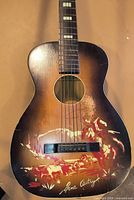 Front view of guitar showing sunburst finish and western graphic