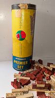 Minibrix Premier Set canister upright with red and cream bricks scattered