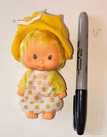 Front view of Butter Cookie doll next to a marker for scale