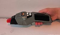 Left side view of entire phaser showing gray body, black grip, orange tip