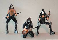 Front view of all three KISS action figures standing and kneeling