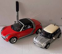 Front/side view of both diecast cars with Sharpie for scale