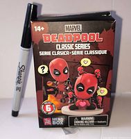 Front of sealed Marvel Deadpool Classic Series blind box beside Sharpie for scale