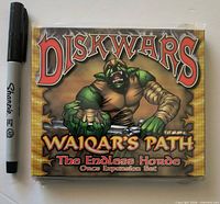 Front of sealed Diskwars Waiqar's Path The Endless Horde Orcs Expansion Set box beside marker for scale