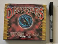 Front of sealed Diskwars Uthuk Y'llan Army Set box beside marker for scale