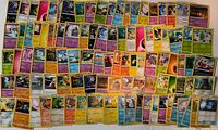 Full spread of approximately 100 Pokémon cards showing variety of types and artwork