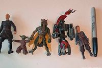 All five figures lined up beside Sharpie for scale