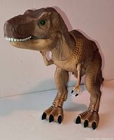 Front view of brown T-Rex figure showing texture and green eyes