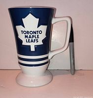 Blue side of mug showing maple leaf logo with Sharpie for scale
