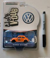 Front view of sealed GreenLight Club V-Dub Volkswagen Beetle Classic on card with Sharpie for scale