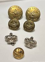 Front view of all seven buttons displaying designs and relative sizes