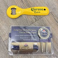 Front view of Corona bottle opener and packaged Crown Royal divot tool with ball marker