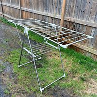 Full view of drying rack set up, showing foldable X-frame and upper rails