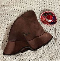 Hat, sombrero, and spoon grouped on crochet surface