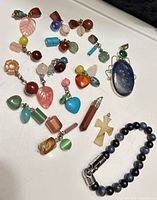 Group shot displaying all pendants, charms and bracelet laid out