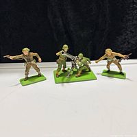 Group shot of all four painted metal WWII soldiers on green bases