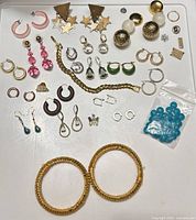 All items laid out on white tray showing earrings, bracelet, bangles, bead bag and findings