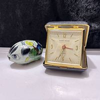 Clock closed next to ceramic figurine