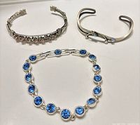 All three bracelets laid flat showing designs and stones