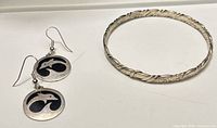 Bangle and both earrings laid flat showing overall design and condition