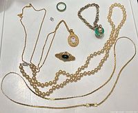 All jewelry pieces laid out including necklaces, bracelet, brooch, ring and rhinestone