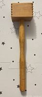 Full view of wooden meat tenderizer showing handle and head profile