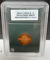 Front view of sealed INB slab displaying certification label and coin