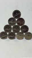 Front view of 11 Voyageur dollars stacked in pyramid formation