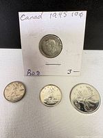All four coins displayed; 1945 dime in flip, three loose coins below