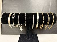 All nine bracelets displayed on black velvet stand