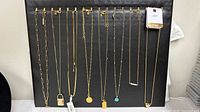 All eight necklaces displayed on black board showing pendants and chain styles