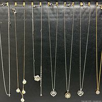 All necklaces hanging, showing chains, pendants, extenders, metal tones