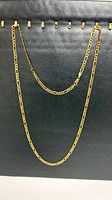 Full view of gold-plated sterling silver Figaro necklace showing overall length and clasp
