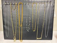 All eight necklaces hanging on display board