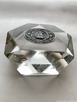 Overall view of octagonal cut-glass paperweight showing medallion