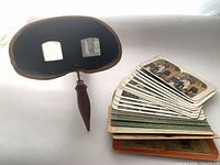 Underwood stereoscope with wood handle and stack of stereograph cards