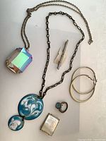 Group shot of all items – two necklaces, ring, earrings, brooch, tie bar
