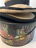 Hatbox with three hats stacked on top