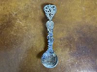 Full view of ornate silver spoon showing bowl and handle