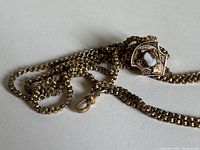 Chain coiled showing cameo slide detail and clasp