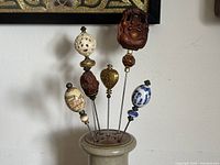 All six hat pins displayed in stoneware holder