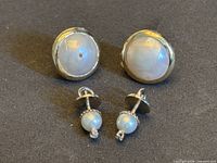 Front view of both earring pairs showing pearl faces and size comparison