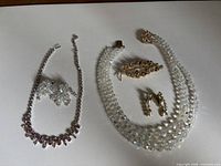 All five jewelry pieces laid out: Sherman necklace and earrings, crystal bead necklace, leaf brooch, pearl drop earrings